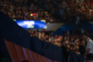 Audio-Technica stellte im Februar die gesamte Ambience-Mikrofonierung für die Intel Extreme Masters in Kattowitz. In Kooperation mit Audio-Technica entwickelte Veranstalter ESL Faceit Group ein neues Aufnahmekonzept und setzte maßgeblich auf die Mikrofone der Marke. Durch den Einsatz von 3D-, Stereo- und Richtrohrmikrofonen wurde die Arena-Atmosphäre immersiv eingefangen und im Livestream abgebildet. Um Übersprechungen der PA in der Arena auf den Ambience-Sound zu minimieren, setzte man auf ein spezielles Konzept für die Mikrofonierung. Ziel war es, ein geeignetes Setup zu finden, das bei allen zukünftigen Veranstaltungen dieser Art eingesetzt werden kann. Der Produktkatalog von Audio-Technica bot dafür die passenden Werkzeuge: Vor den Zuschauerrängen wurden die BP4025 Mikrofone aufgestellt. Durch ihre X/Y-Stereokapsel konnte ein authentisches Abbild des Publikums eingefangen werden. Ergänzend kamen die Stereo-Richtrohrmikrofone BP4029 auf Handkameras und der Spidercam zum Einsatz, um die Stimmung direkt in den Rängen wiederzugeben. Um den Zuschauern des Livestreams ein immersives Erlebnis zu bieten, wurde die Mikrofonierung auf zwei weitere Ebenen ausgeweitet. Unter der Hallendecke war mit dem BP3600 ein 3D-Mikrofon angebracht, das durch Diffusschall die Dimensionen der Arena akustisch reproduzierte. Hinzu kamen von der Decke hängende AT4050ST, die eine klangliche Brücke zwischen Diffusschall und dem Direktschall des Publikums bildeten. Dank deren M/S-Kapseln wurden die Gesamteindrücke der Zuschauer sowie des Veranstaltungsortes verstärkt und gleichzeitig PA-Übersprechungen durch das Off-Axis-Verhalten minimiert. Um eine objektive Beurteilung des Konzepts und ein detailliertes akustisches Abbild des Events vornehmen zu können, wurde in der Arena eine Testregie eigens für den Atmo-Mix eingerichtet. Auf einem dLive C1500 mit DM32 Mixrack von Allen & Heath wurden die Signale der Audio-Technica Mikrofone im Klangfeld entsprechend positioniert und aufeinander abgestimmt. Der Atmo-Mix wurde über Glasfaser an die 15 Kilometer entfernten ESL-Studios gesendet, wo dieser über eine Allen & Heath dLive S5000 mit anderen Signalen für den finalen Broadcast-Mix für den Livestream vereint wurde. https://www.audio-technica.com/de-de/ Intel Extreme Masters setzten auf Audio-Technica Mikrofone (Fotos: Audio-Technica Deutschland)